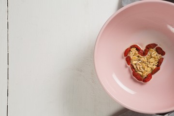 Obraz na płótnie Canvas Dried fruits forming heart shape in plate