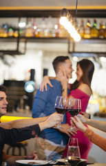 friends toasting with wine and couple in love