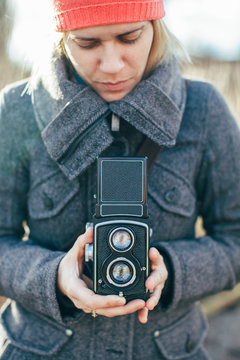Young woman holding medium format twin lens reflex camera