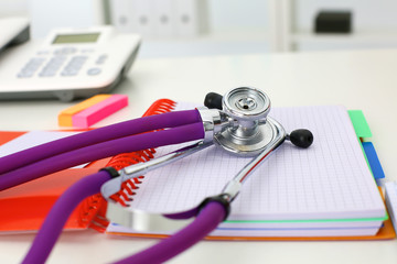 Doctor's workspace working table with patient's discharge blank paper form, medical prescription, stethoscope on desk