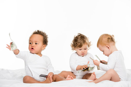 multiethnic toddlers holding cash