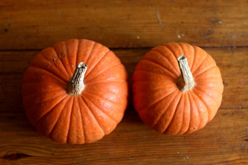 Two orange pumpkings close up on brown background, halloween texture