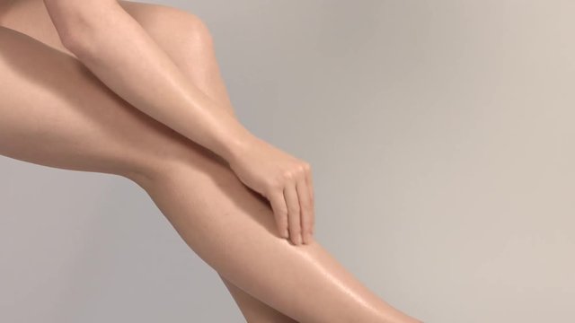Beautiful female legs overgrey background.
