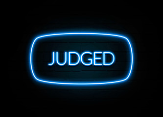 Judged  - colorful Neon Sign on brickwall