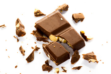 Piece of chocolate with hazelnuts set in several on a white background