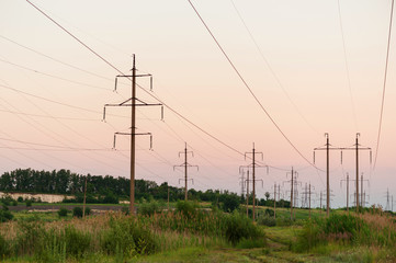 Fototapeta na wymiar poles with high voltage wires near water