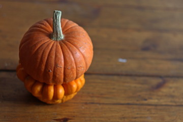 Cute orange pumpkin on wooden brown background, halloween pattern