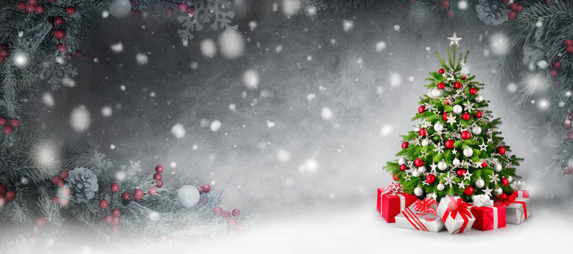 Weihnachtshintergrund mit Christbaum und Geschenken im Schnee, umrahmt mit Tannenzweigen