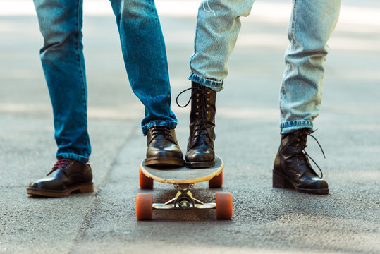 couple standing together on one longboard