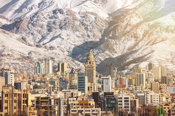 Winter Tehran  view with a snow covered Alborz Mountains on background. With lens flare and light leak