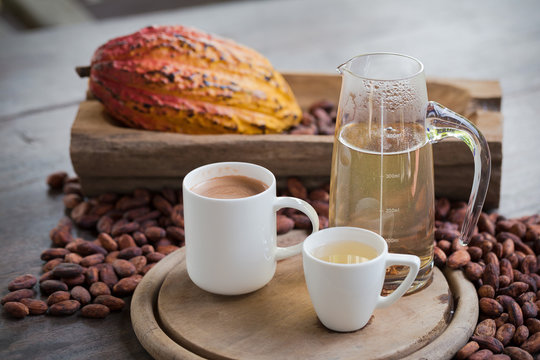 Hot cocoa and milk, Ripe cocoa pod and beans setup on rustic wooden background
