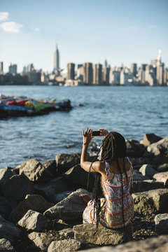 Young black woman relaxing against New York skyline