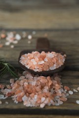Fototapeta na wymiar Himalayan salt and rosemary on wooden table
