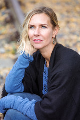 blond woman sitting outside and looking pensive