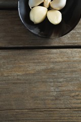 Garlics in plate on wooden table