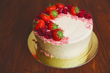 Christmas cake with berries on wooden background