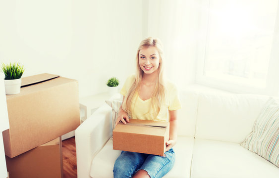 smiling young woman with cardboard box at home