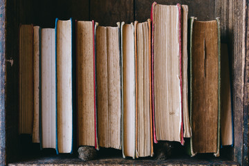 Close up of old hardcover books in a wooden books