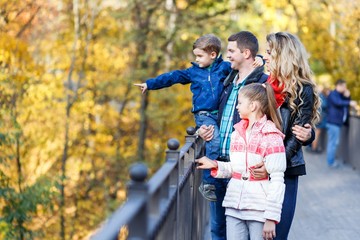 Fototapeta premium A happy family having fun in the park in autumn. Family, love, happiness concept. Family of four