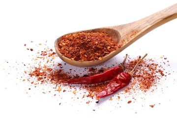 Dry red hot chili peppers with flakes in wooden spoon, pile isolated on white background