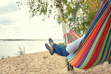 Frau genießt eine Auszeit am See in der Hängematte