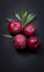 Fototapeta na wymiar Fresh plums on black wooden table