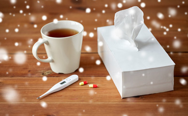 cup of tea, paper wipes and thermometer with pills