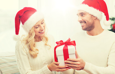 happy couple at home with christmas gift box