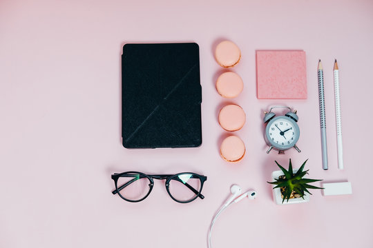 Woman Desk on pink glasses notepad kicking pencils plant macaroons alarm clock Top View Space For Text