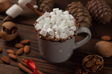 Obraz na płótnie Canvas Winter hot drink, cacao with marshmallows and cones, nuts, cozy home still life