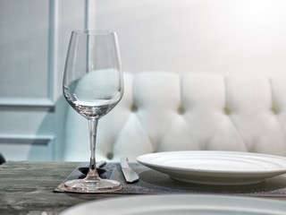 Table set with wineglass, dish, spoon and knife for romantic lunch or dinner.