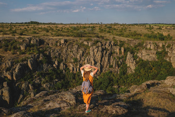 Obraz premium happy young girl standing on a background of the canyon. View from the back
