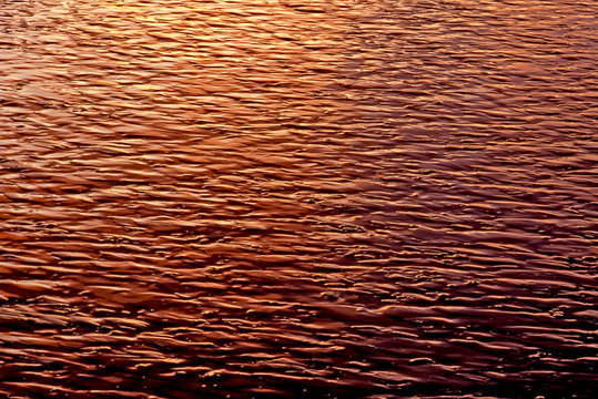 late afternoon sun reflected on patterns in the wet sand at low tide