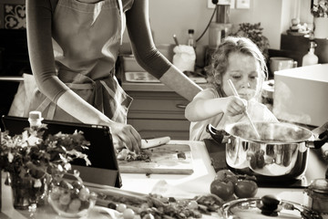 A mother and her daughter cooking a recipe in the kitchen