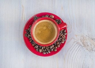 red cup of coffee on light wooden background top view