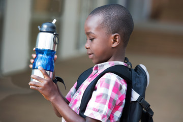 little boy holding a bottle of water © vystekimages