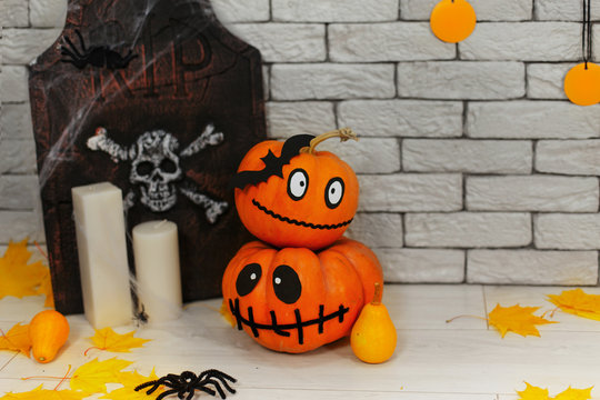 Halloween holiday decoration with tombstone, spiders and pumpkins with funny face