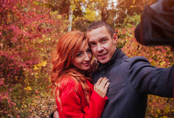 Couple taking selfie in autumn forest