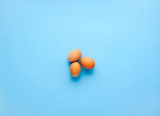 three chicken eggs isolated on blue background