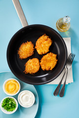 cooking pancakes in a non-stick frying pan on a blue background
