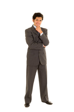 Full length of a handsome young man with curly hair, wearing a nice suit, and posing in a white background