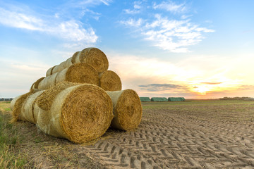 Strohballen beim Sonnenuntergang mit strahlend blauem Himmel