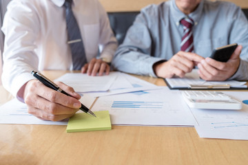 Two confident executives business colleagues meeting and discussing ideas of project about company offer, they is pointing on a contract and giving explanations, team of successful business people