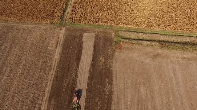 Tractor cultivating wheat stubble field, crop residue.