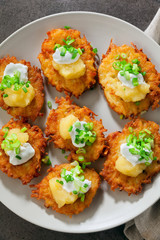 Potato pancakes, latkes or boxty and sauces from sour cream, yogurt, apple sauce and finely chopped green onion on grey stone background