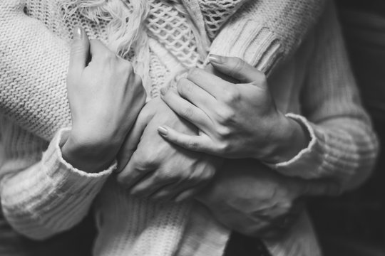 her husband gently hugs her girlfriend