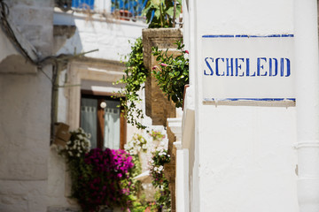 Road sign with street dialect name in a Puglia road