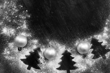 Christmas snow frame with silhouettes of trees and Christmas balls on a black background