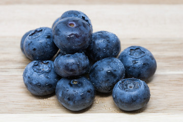 Close up of fresh Blueberries on wooden chopping board, sprayed with water.
