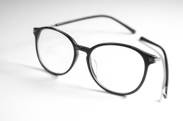 Old glasses on broken legs on white background,selective focus